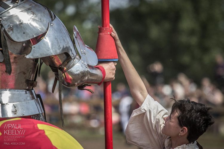 Emma Wasson hands a lance up to a jouster at Brooks 2014 (photo by Paul Keely)