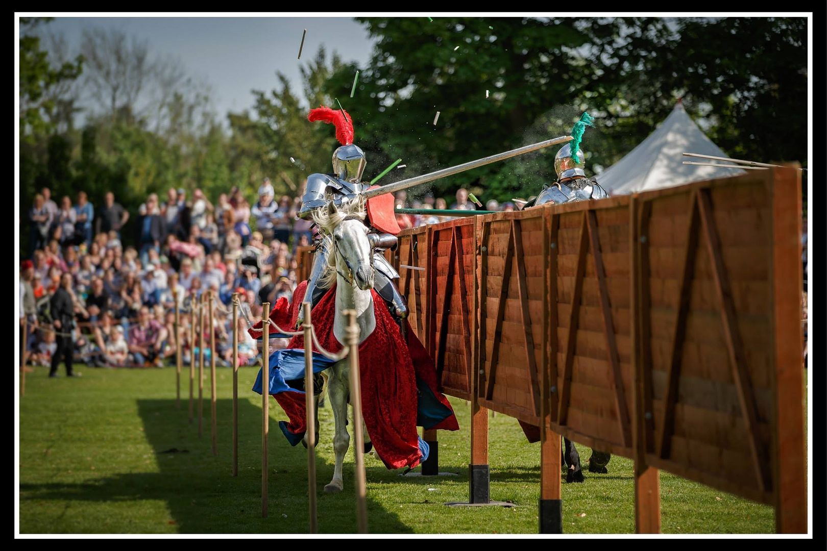 Benedict Green(right, green feathers) breaks his lance against Jason Kingsley(left, red feathers) during Ben's first professional joust at Hedingham Castle 2014 (photo by NWY Photography)