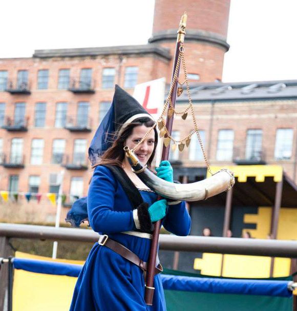 A young lady carries the Queen's Golden Jubilee Horn during the 2013 tournament (photo from Royal Armouries)